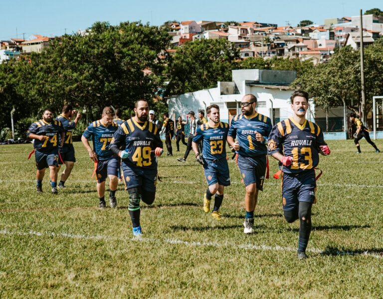 Meci de minifotbal între echipe de amatori pe un teren din parc, urmărit de vecini