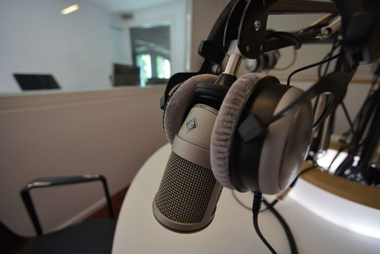 Microfon de studio și căști pe o masă, într-un studio de radio pregătit pentru un interviu